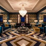 A luxurious and elegant Art Deco living room featuring bold geometric patterns, sleek mirrored furniture.